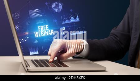 Businessman working on laptop with FREE WEBINAR inscription, new business concept Stock Photo