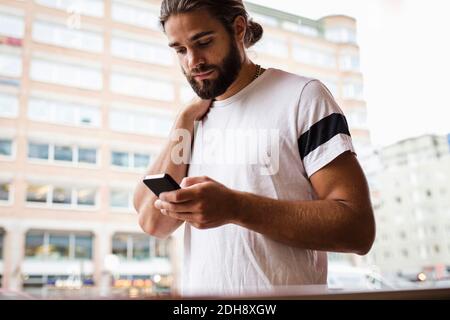 Man using smart phone while walking in city Stock Photo