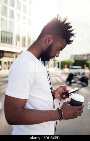Young man in profile using smartphone Stock Photo