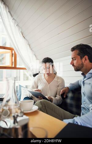 Mid adult businessman with female colleague using digital tablet in office Stock Photo