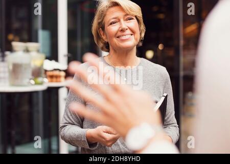 Happy businesswoman looking at female colleague outside restaurant Stock Photo