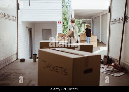 Female friends carrying cardboard boxes during relocation Stock Photo