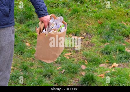 Paper and cardboard prepared for recycling. Recyclable materials. Man holds a package of paper and cardboard in his hand for recycling. Stock Photo