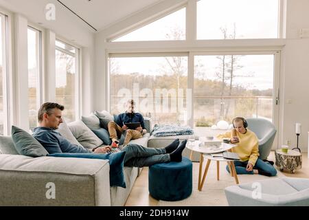 Father and children using wireless technology at home Stock Photo
