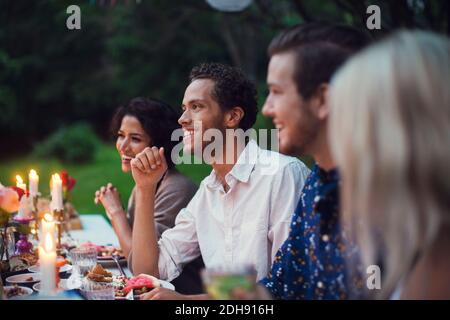 Happy friends having meal at table during garden party Stock Photo