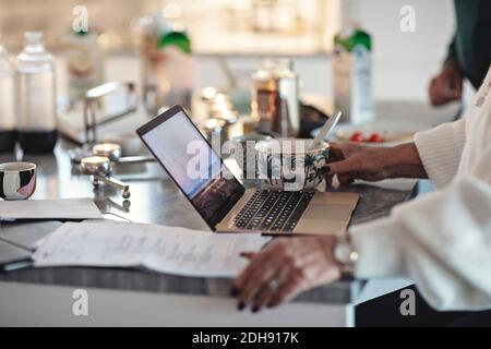 Midsection of senior woman using laptop over table at home Stock Photo