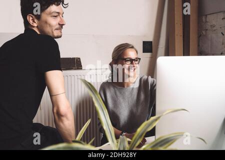 Smiling computer programmer with coworker at workplace Stock Photo