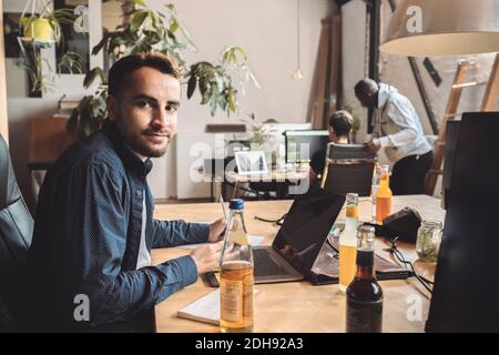 Portrait of entrepreneur working on laptop at workplace Stock Photo