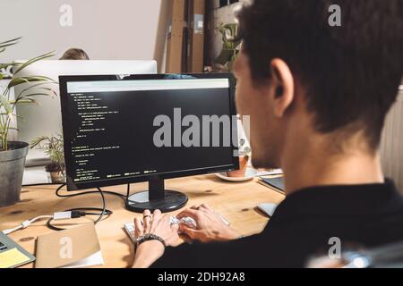 Computer programmer coding on desktop at workplace Stock Photo