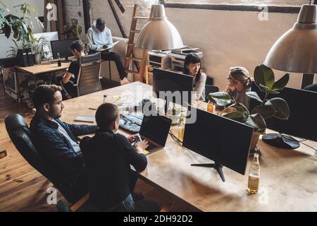 Male and female computer programmers working over desk at place of work Stock Photo