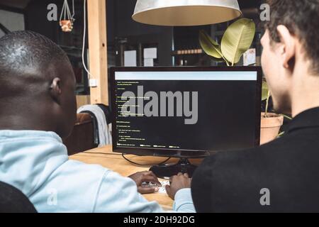 Computer programmers working on coding at workplace Stock Photo