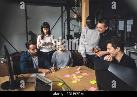 Colleagues discussing over start-up strategy at workplace Stock Photo