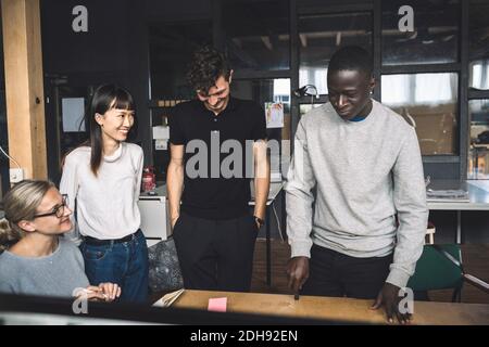 Smiling colleagues discussing over start-up strategy at workplace Stock Photo