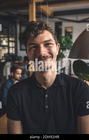 Portrait of smiling computer programmer at workplace Stock Photo