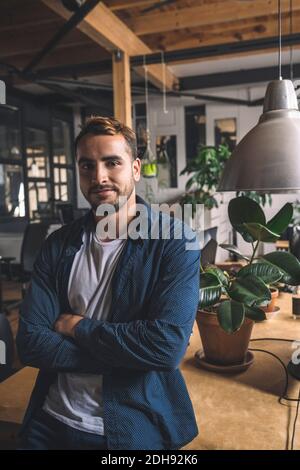 Portrait of confident businessman with arms crossed at new workplace Stock Photo