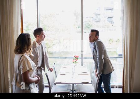 Business people standing by table against window at restaurant Stock Photo