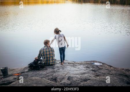 Rear view of father and daughter fishing at lake Stock Photo