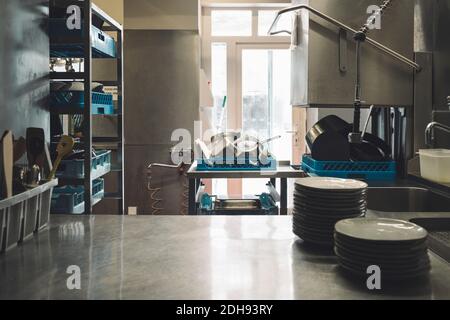 Plates arranged on kitchen counter in restaurant Stock Photo