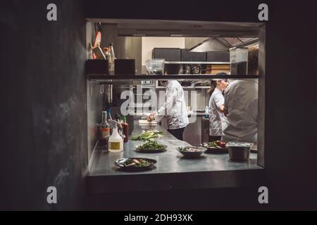 Male and female chefs working in restaurant Stock Photo
