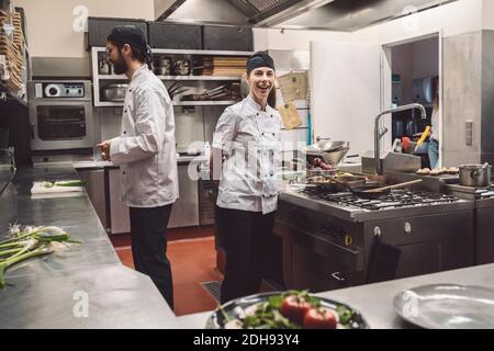 Portrait of smiling chef with coworker in kitchen restaurant Stock Photo