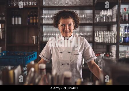 Portrait of smiling female chef in commercial kitchen Stock Photo