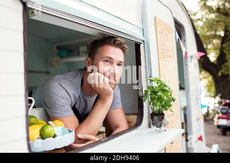 Thoughtful male owner looking out through food truck window Stock Photo