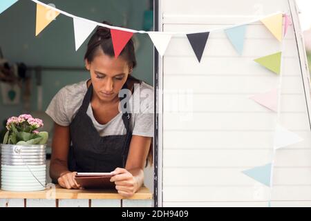 Female owner using digital tablet in food truck Stock Photo