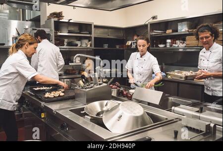 Chefs preparing food in commercial kitchen at restaurant Stock Photo