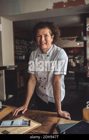 Portrait of smiling mature chef standing in restaurant Stock Photo