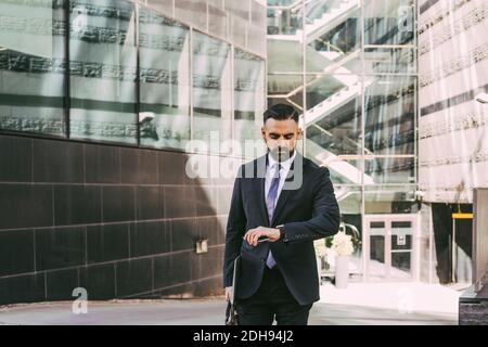 Businessman checking time in city Stock Photo
