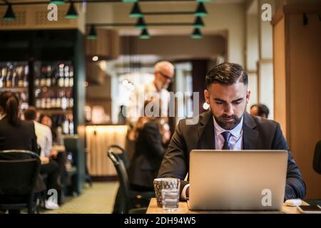 Businessman using laptop in restaurant Stock Photo