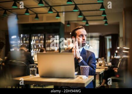 Worried businessman looking away while sitting in restaurant Stock Photo