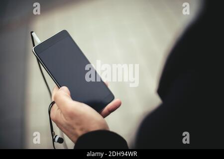 Cropped image of businessman using mobile phone on city street Stock Photo