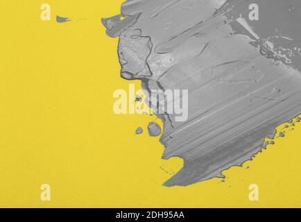 Colors of the year 2021 Ultimate Gray and Illuminating background.  Ultimate gray paint on yellow illuminating background. Stock Photo