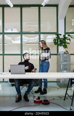 Two colleagues talking at desk in office Stock Photo