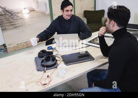 Two men discussing at desk in creative office Stock Photo