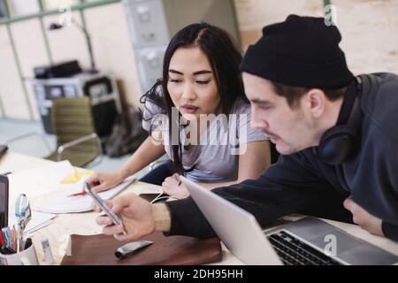 Young woman and man using smart phone at desk in office Stock Photo