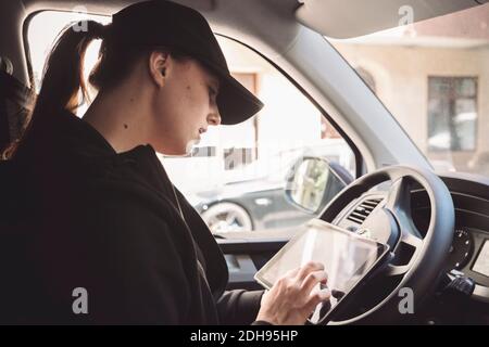 Side view of driver using digital tablet in truck Stock Photo
