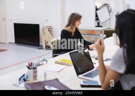 Two young women working at desk in creative office Stock Photo