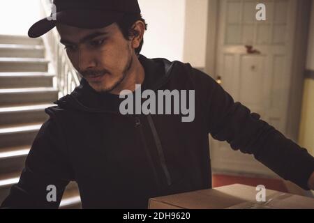 Confident delivery man with package making home delivery Stock Photo