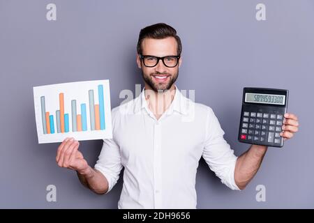 Portrait of his he nice attractive smart clever skilled cheerful cheery brunet guy financier holding in hands showing earnings result progress Stock Photo