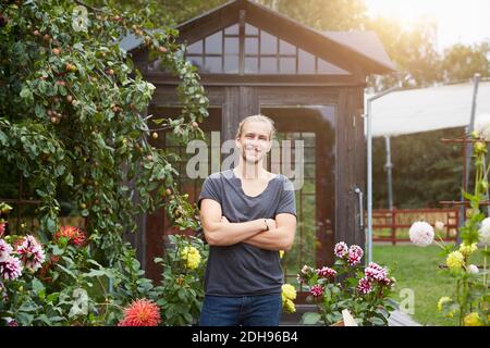 Portrait of male gardener with arms crossed smiling in yard Stock Photo