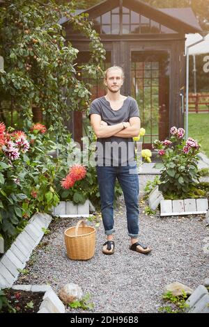 Portrait of male gardener standing arms crossed in yard Stock Photo