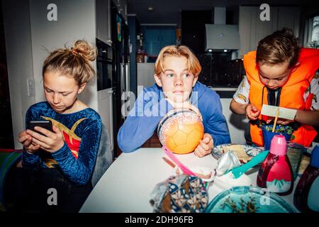 Male and female siblings sitting at table Stock Photo