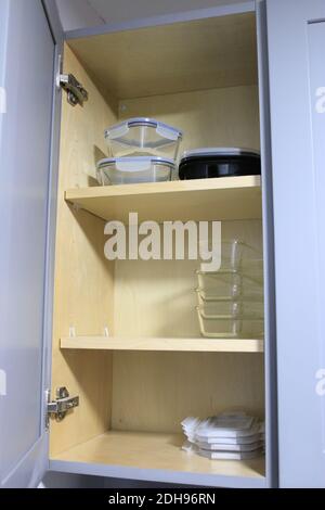 organized glass food storage containers in cupboard Stock Photo