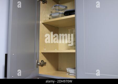 organized glass food storage containers in cupboard Stock Photo