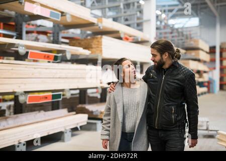 Couple looking at each other while walking in hardware store warehouse Stock Photo