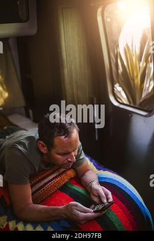 High angle view of man using phone in camper trailer Stock Photo