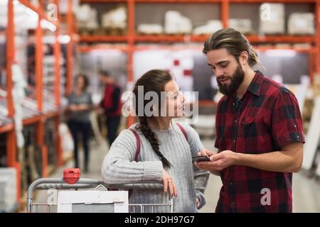 Couple using smart phone in hardware store Stock Photo