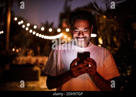 Happy man texting during sunset Stock Photo